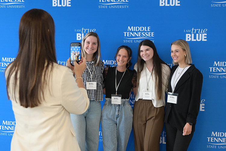 Middle Tennessee State University associate marketing professor Lucy Matthews, left, snaps a photo of a group of Middle Tennessee State University students attending the 2025 Tech Vision Conference held April 10-11 in the Miller Education Center atrium on Bell Street on the MTSU campus in Murfreesboro, Tenn. (MTSU photo by Jimmy Hart)