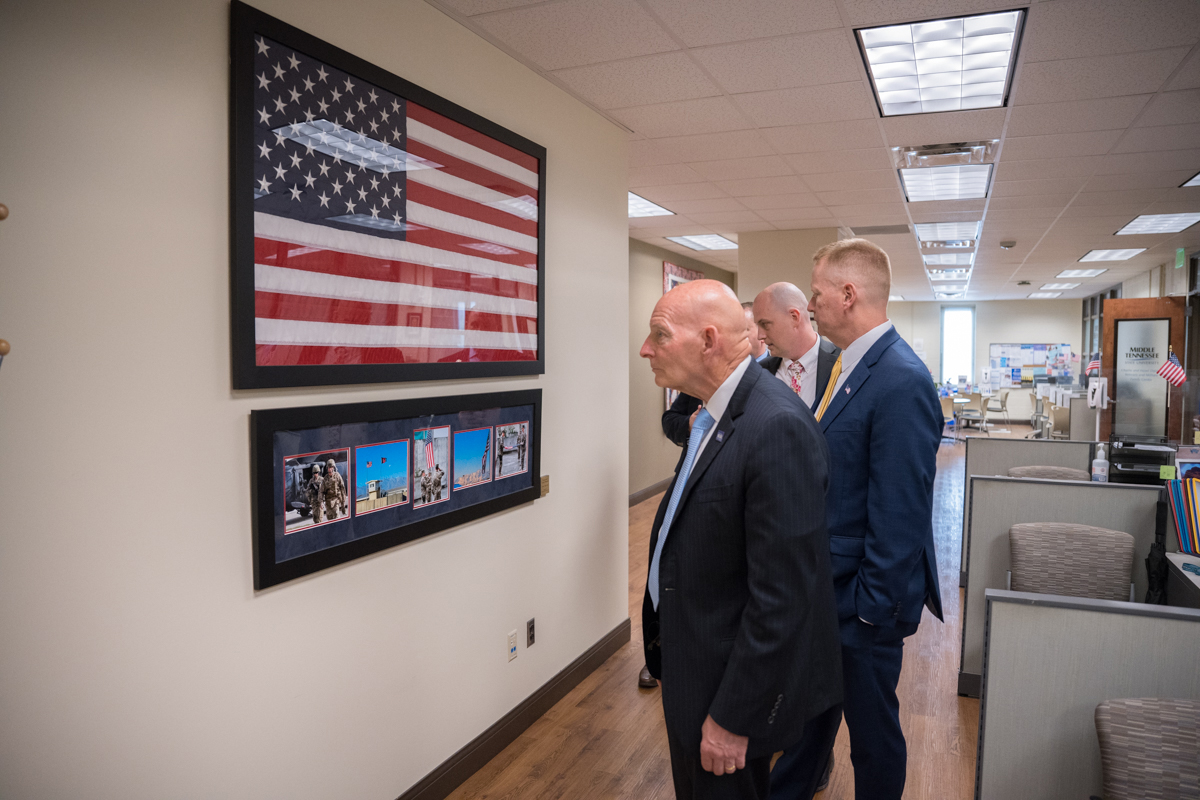 On a tour of the Daniels Veterans Center, Keith M. Huber, foreground, senior adviser for veterans and leadership initiatives, shares about one of many wall decorations as Tennessee Valley Healthcare Systems leaders Daniel Dücker and Michael Renfrow listen. They came for a recent visit to meet Huber and other Daniels Centers staff and administrators. (MTSU photo by James Cessna)