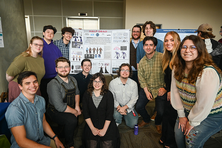 Middle Tennessee State University animation students and their professor pose with their animation project poster at the MTSU Undergraduate Research Center’s sixth annual Open House on Thursday, Nov. 9, at the Science Building on campus. Standing, from left, are Bailey Holland, Lance Harbour, Drew Lacey, animation professor Corey Reece, Seth Savage, Elvis Hertado, Natalie Rapier and Emma Gresham. Kneeling, from left, are Sean Kangas, Zachary Legaux, Andy Belcher, Audrey Roberts, and Josh Mahan. (MTSU photo by Stephanie Wagner)