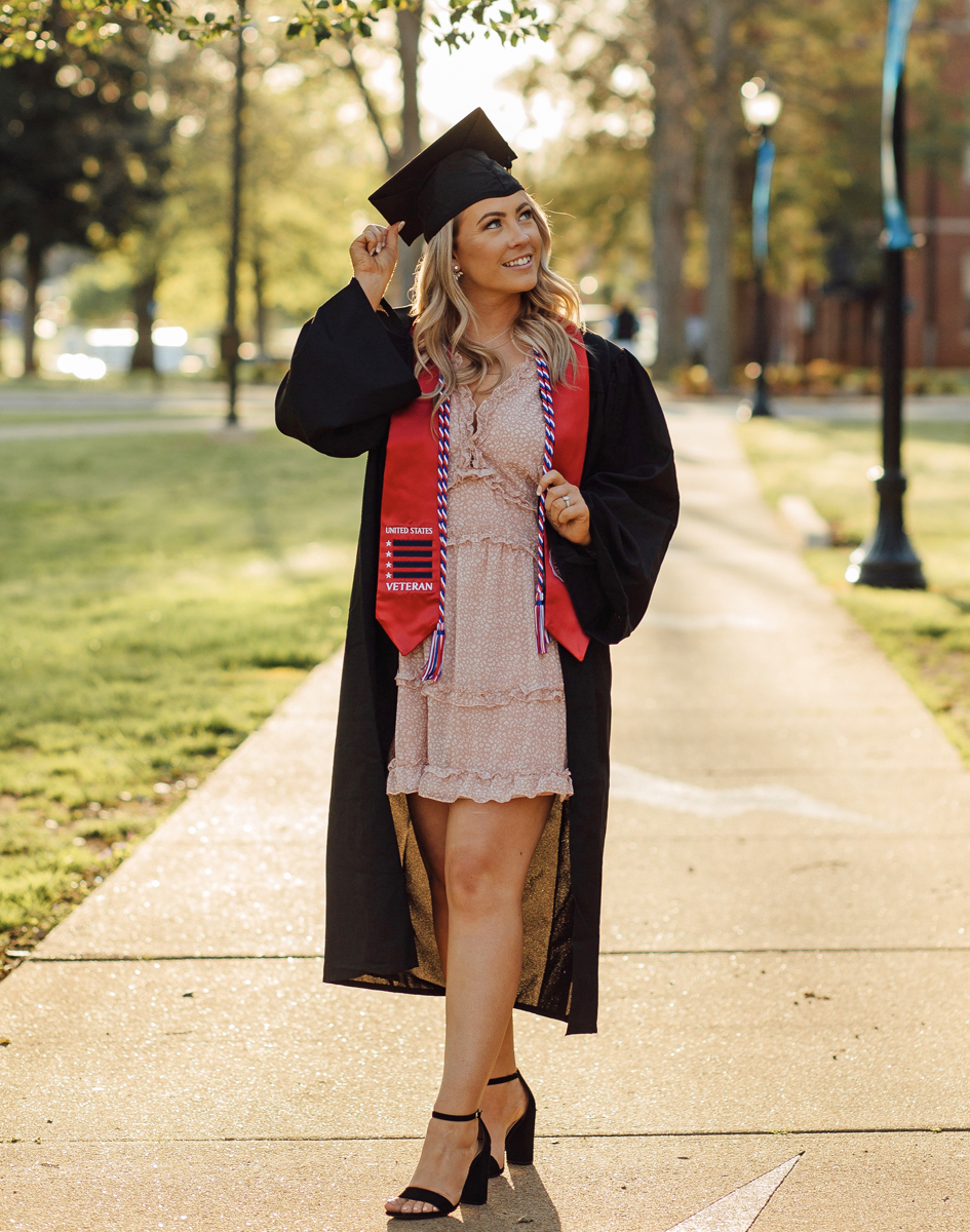 Wearing her MTSU red stole, graduating student veteran Vanessa VanCleve had professional cap-and-gown photos taken, only to learn the May 2020 MTSU commencement was canceled because of the coronavirus pandemic. She has been in the School of Concrete and Construction Management program since 2017. (Photo by Lindsay Collett/SincerelyLindsayPhotography.com)