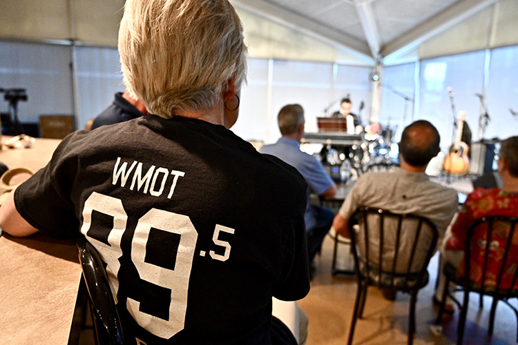 A WMOT Roots Radio 89.5 listener sports a T-shirt of support while she and others listen to indie-folk artist A.J. Croce during his live set at the radio station’s 50th anniversary celebration held Tuesday, April 9, at the Cyber Cafe on the MTSU campus. (MTSU photo by J. Intintoli)