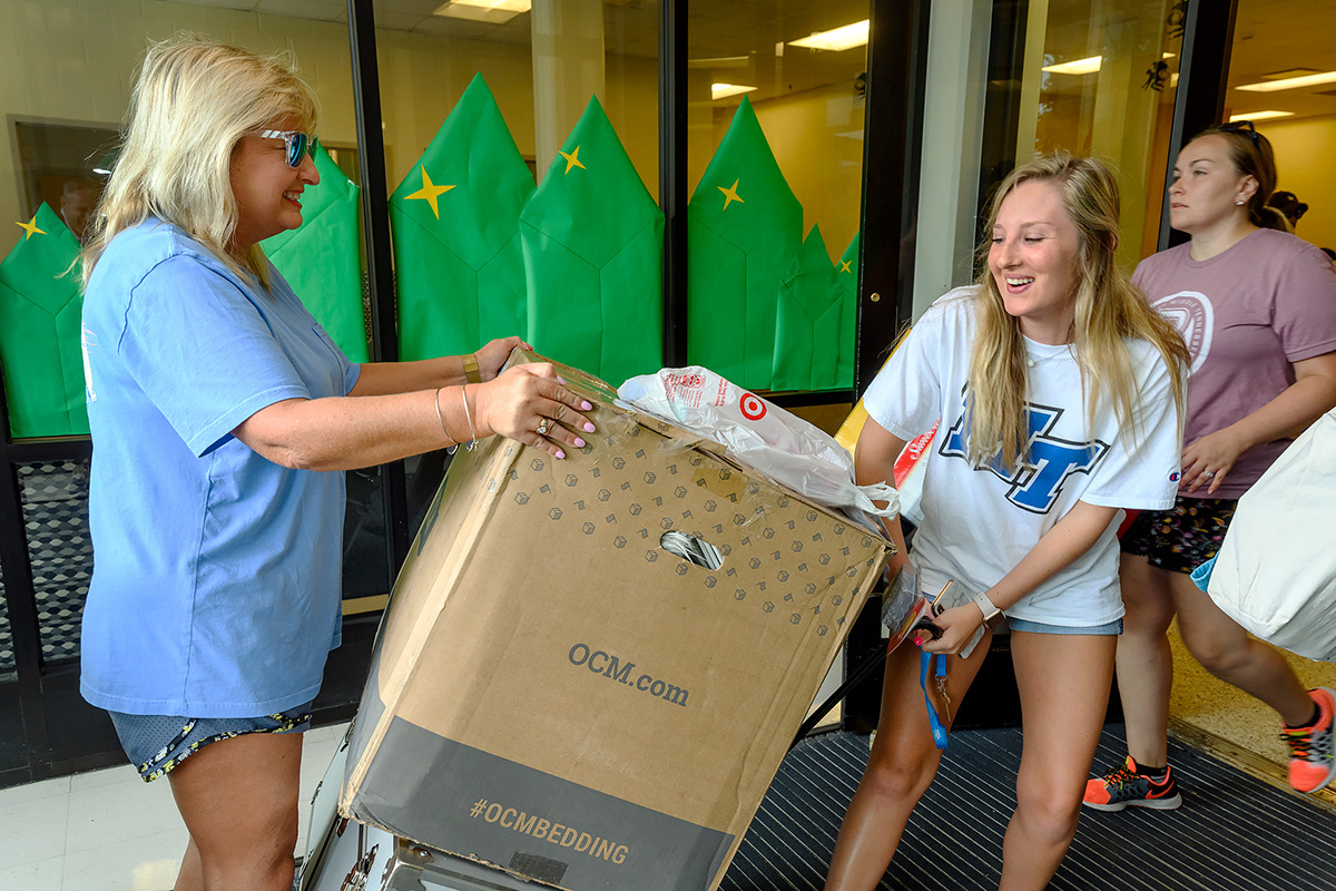 Madison Ratliff, 19, right, of Bristol, Tenn., and her mother, Sherry Ratliff, haul in a large box and chest as part of the new MTSU freshman’s belongings being carried into Corlew Hall Friday, Aug. 23, as part of the MTSU Center for Student Leadership and Involvement’s We-Haul move-in effort. Madison Ratliff is an early childhood education major. (MTSU photo by J. Intintoli)