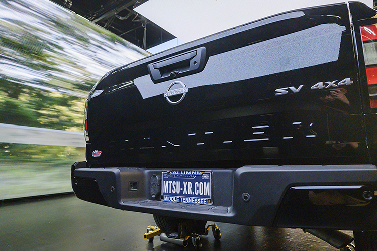 A custom license plate promotes MTSU's new extended reality, or XR, stage, as footage of a speedy drive down a mountain road plays on an LED screen in the background during production of a "teaser" commercial in Nashville for the Department of Media Arts' new facility, the only one of its kind at a Tennessee university. The XR stage, a new type of film and video production stage that will enable them to create projects anywhere, anytime, will be ready for MTSU classes this fall. (MTSU photo by Andy Heidt)