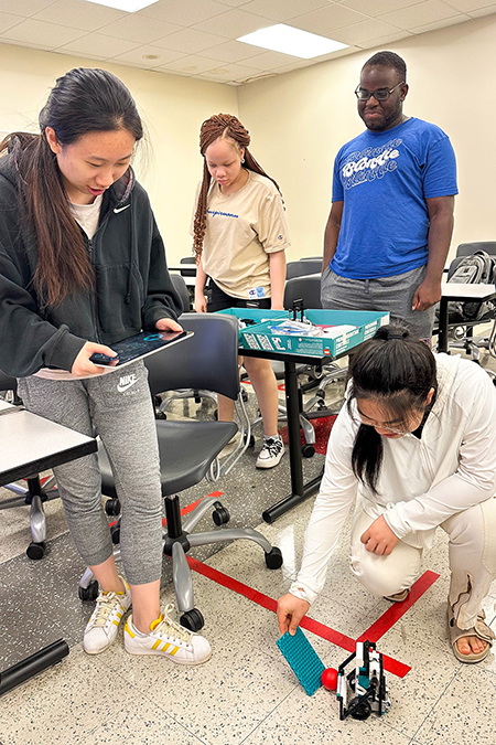 Middle Tennessee State University computer science students have fun with robots as part of a summer enrichment program to support female computer science students at the Kirksey Old Main Building on campus on June 29, 2023. Standing, from left, are Haiting Cai, Christabel Obi-Nwosu, Kosy Okafor and Xingyu Chen. (MTSU photo courtesy of Yi Gu)