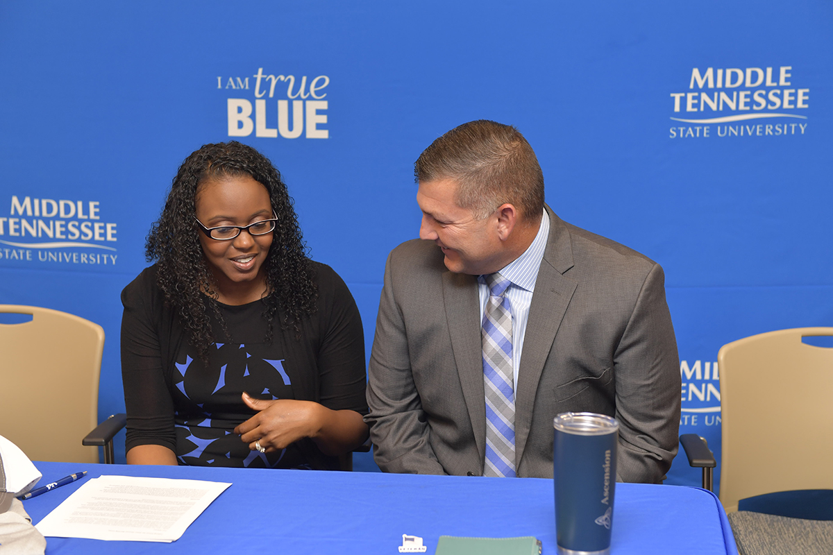 MTSU student veteran Martinna Young, left, visited with Ascension Saint Thomas healthcare recruiter Shane Smith Tuesday, Nov. 26, as Young was the inaugural Ascension Saint Thomas Nursing Corps member at the MTSU Daniels Veterans Center during a special ceremony. Young is a wife, mother of three daughters and a U.S. Air Force veteran. (MTSU photo by James Cessna)
