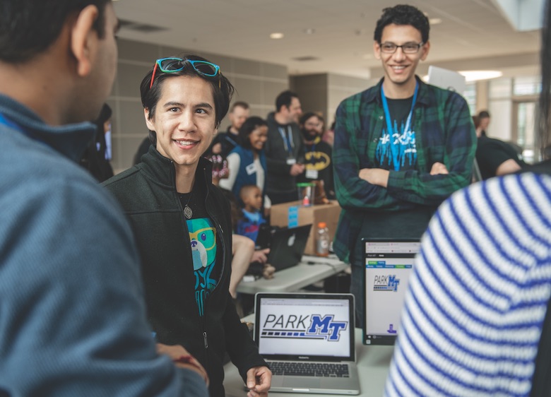MTSU sophomore Samuel Remedios, a computer science major, explains his Team 8 project ParkMT to attendees. Fellow teammate Kirolos Shahat from UT Knoxville is standing in the background with arms folded. They were attending the second annual MTSU Hackathon, HackMT, where students, alumni, faculty and industry mentors from MTSU, as well as from other universities across the state, spend 36 straight hours developing computer software technology products, then present them to be judged at a fair in the Science Building Atrium.