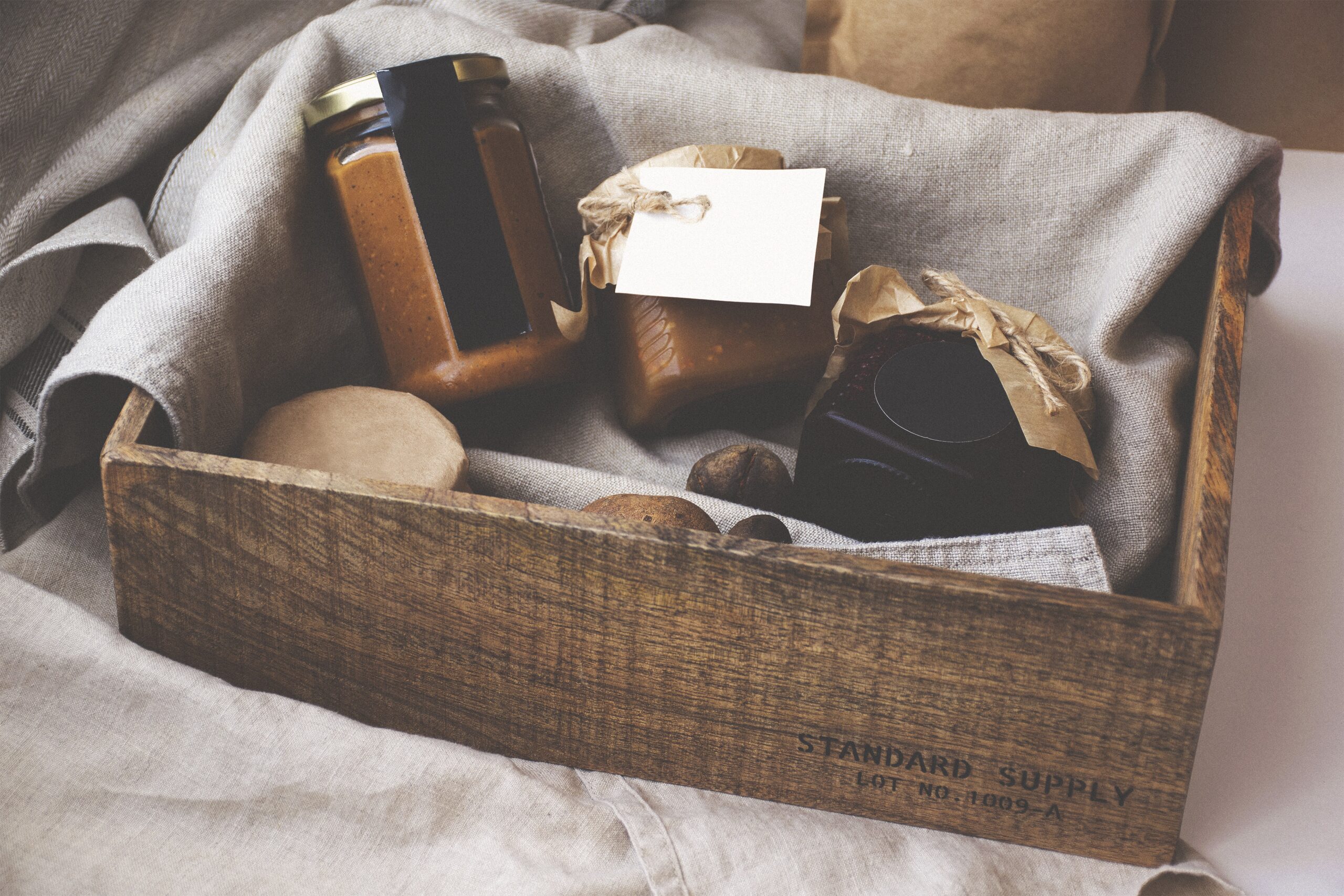 woven basket containing jars filled with different jams