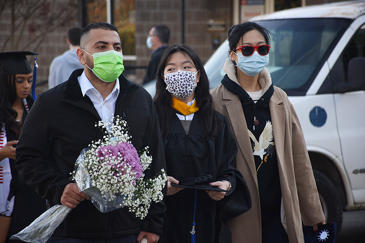 A trio of supporters heads toward MTSU's Floyd Stadium Saturday, Nov. 21, to join the university's fall 2020 commencement ceremonies. MTSU, which held virtual graduations for its May and August graduates because of the pandemic, required strict mask, physical distancing and other health protocols for the graduates and limited their guests to help keep the open-air event safer. (MTSU photo by GradImages)