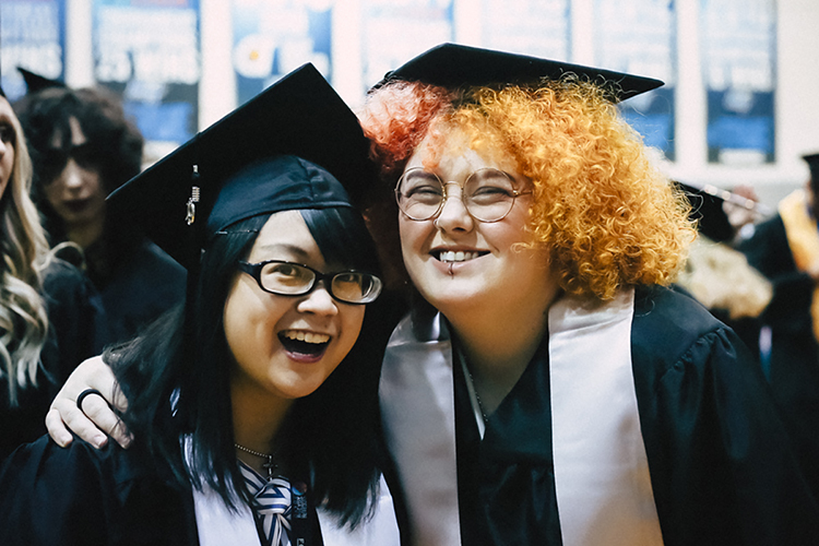 Two new MTSU graduates celebrate inside Murphy Center at the university's fall 2019 afternoon commencement ceremony on Saturday, Dec. 14. (MTSU photo by GradImages)