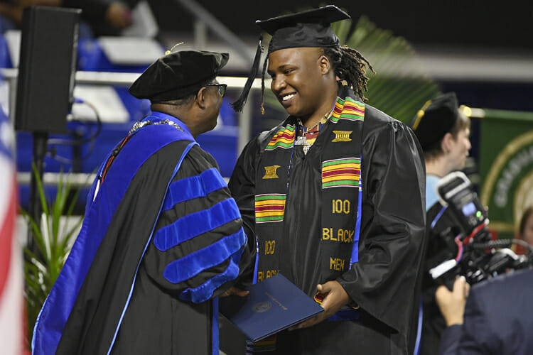 MTSU senior BryTavious Chambers of Memphis, known professionally as “Tay Keith,” accepts his bachelor’s degree in integrated studies from President Sidney A. McPhee during the university’s fall 2018 commencement ceremonies Saturday, Dec. 15. Chambers earned his degree from MTSU’s University College the same month a rap single he produced, Travis Scott’s “SICKO MODE,” went double platinum and No. 1 on the Billboard Hot 100 chart and was nominated for two Grammy Awards. (MTSU photo by Andy Heidt)