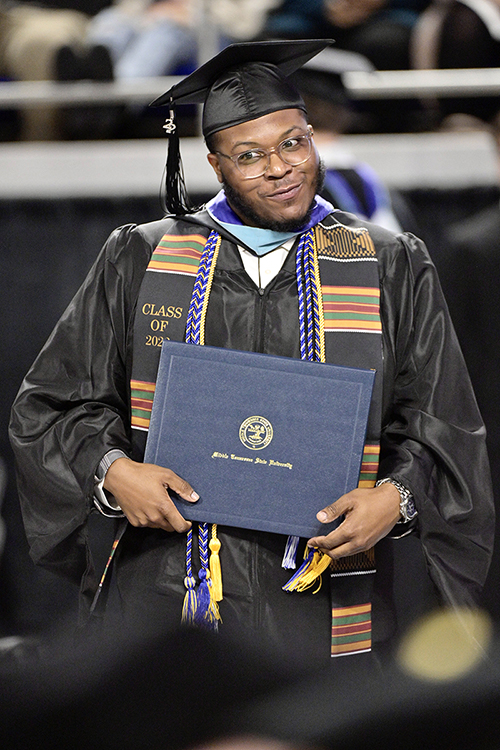 MTSU fall Class of 2022 graduate Jalen Mims cuts a joking side-eye at a fellow new graduate as he returns to his seat, degree in hand, in Hale/Earle Arena inside Murphy Center during the university's Dec. 10 commencement ceremonies. MTSU presented 1,698 students with their degrees — 1,345 undergraduates and 353 graduate students — to mark the first graduation of its 112th academic year. (MTSU photo by Andy Heidt)