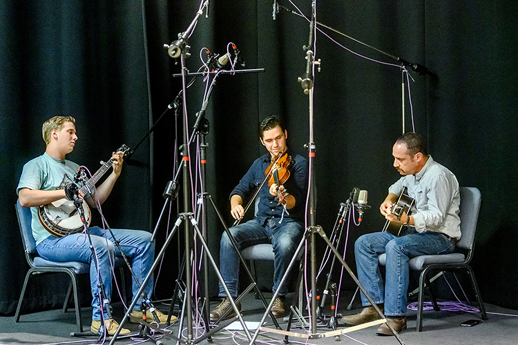 Austin Derryberry of Unionville, Tenn., center, an August 2019 MTSU audio production graduate and award-winning multi-instrumentalist, fiddles along with accompanists Connor Vlietstra, left, on banjo and Greg Reish on guitar during a recording session in the university's Studio A in the Bragg Media and Entertainment Building. MTSU's Center for Popular Music, which Reish directs, is creating its first CD on campus for its Grammy-winning Spring Fed Records label to capture the Derryberry and fellow musician Trenton "Tater" Caruthers' old-time fiddle music. (MTSU photo by J. Intintoli)