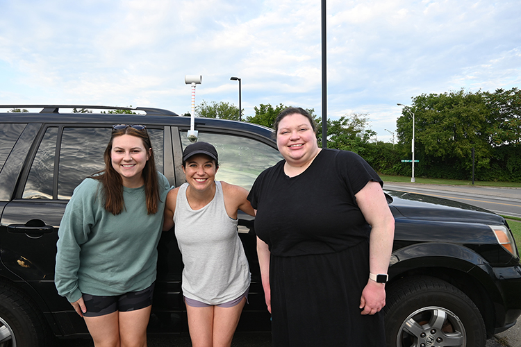 Alisa Hass, right, Middle Tennessee State University professor and climate researcher, Kendra Abkowitz, center, chief sustainability and resilience officer at the Nashville mayor’s office, and a community volunteer work together on the National Oceanic and Atmospheric Administration’s Heat Mapping Campaign for Nashville and distributed heat sensors to volunteers, one pictured on the left, at the Adventure Science Center in Nashville, Tenn. Sensors, like the one shown attached to the car window, recorded temperature, humidity, time and location data as volunteers drove an assigned route around the city on Aug. 14, 2022. (MTSU photo by Stephanie Barrette)