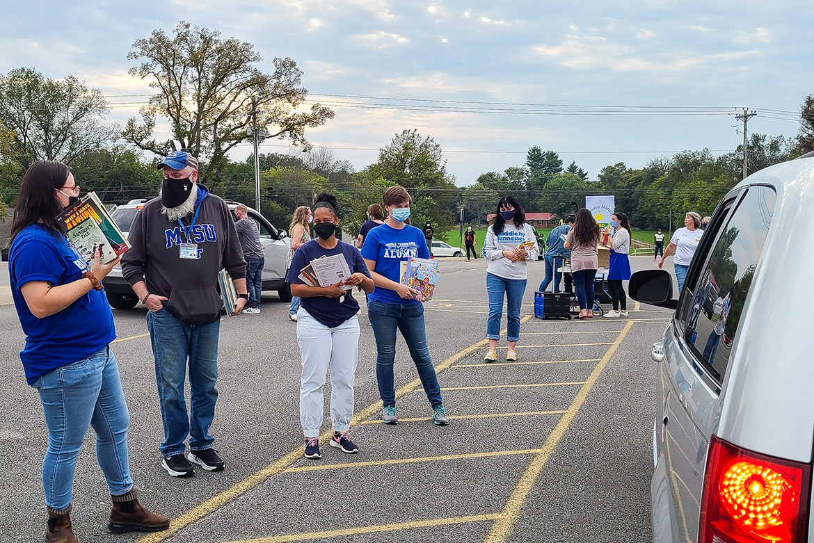 From left, MTSU College of Education students Tiffany Watt, Brian Myers, Lauren Washington, Sara Daily and Traci Hammiel prepare to serve families during the most recent drive-thru Literacy Night event at Walter Hill Elementary School. Staffing the back table, from left, are students Emmy Lyles, Brooke Venkatraman and MTSU alumna Lydia Smith. (MTSU photo by Stephanie Barrette)