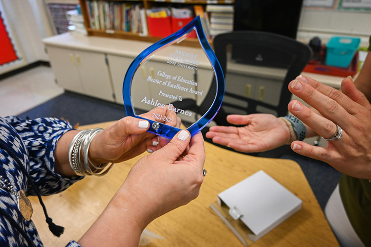 Middle Tennessee State University associate education professor Shannon Harmon, left, surprised Ashlee Barnes, fourth grade teacher at Hobgood Elementary School in Murfreesboro, Tenn., and three other teachers across Rutherford County, with Mentor Teacher of Excellence awards at the end of April for their superb mentorship of education students. (MTSU photo by Stephanie Barrette)