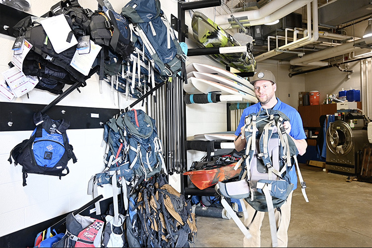Blake Osborn, Middle Tennessee State University outdoor pursuits coordinator, shows off backpacks, some of the new equipment the department purchased after receiving a $70,000 grant from the Tennessee Wildlife Resource Agency to start a university fishing program, at the recreation center on campus on April 14, 2022. (MTSU photo by Stephanie Barrette)