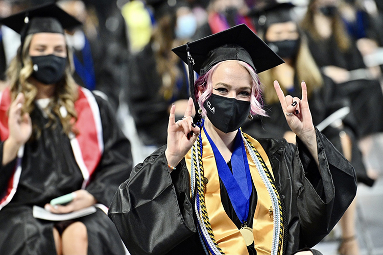 A graduating MTSU student, wearing a special gold stole designating her 4.0 GPA summa cum laude status and a medallion for her work in the University Honors College, celebrates at the College of Liberal Arts commencement in MTSU's Murphy Center Friday, May 7, during the first day of the university's spring 2021 commencement ceremonies. Students returned to Murphy Center May 7-9 for the first time since 2019 for a three-day, 10-event, socially distanced commencement weekend. (MTSU photo by J. Intintoli)