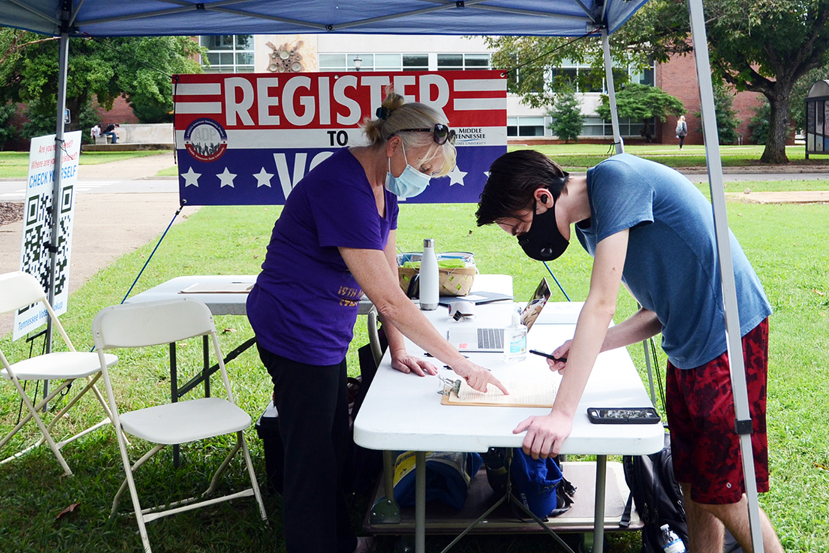 Andrew Lickman, right, a freshman computer science major from Lynn Haven, Florida, registers to vote at a voter registration tent on the south side of MTSU’s Peck Hall. Volunteer and MTSU alumna Lee Anne Carmack of the Murfreesboro chapter of the American Association of University Women handles the paperwork and provides information. (MTSU photo)